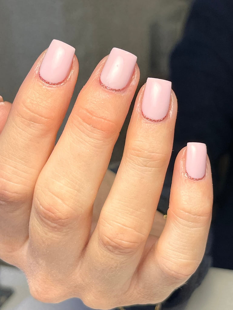 Nude gel nails with pink glitter cuticle detail by Corrine Jackson