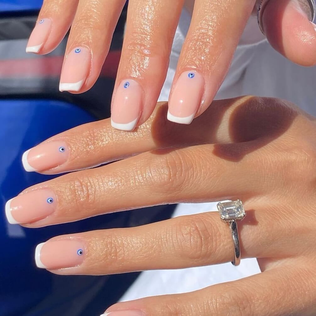 French manicure with blue eye detail at the base by Kendal Gazal