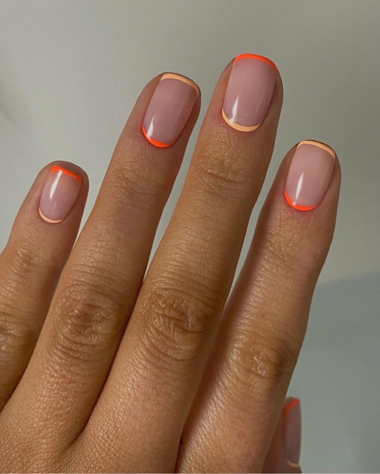 Alternating fluorescent and muted orange nail tip and cuticle detail by Ellie O'Hara
